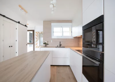 Cocina blanca y madera con sistema gola y encimera porcelánica